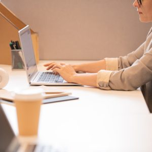 Close-up of serious busy lady in jacket sitting at desk